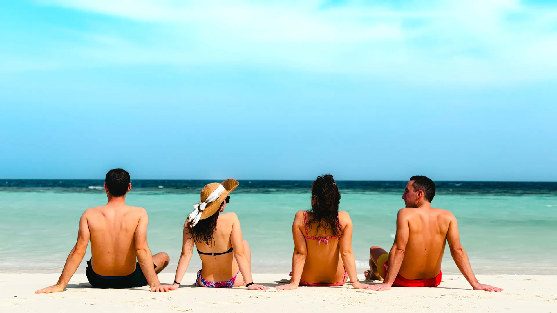 Friends sitting together on the beach